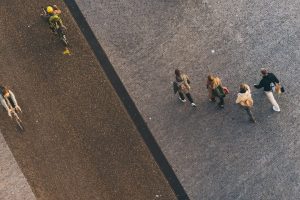 Överblick över cyklister och fotgängare, med ryggsäckar, på en trottoar.