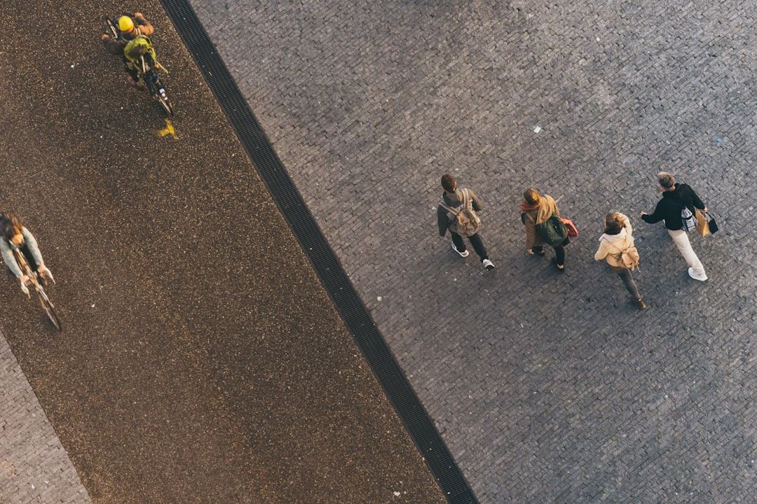 Överblick över cyklister och fotgängare, med ryggsäckar, på en trottoar.